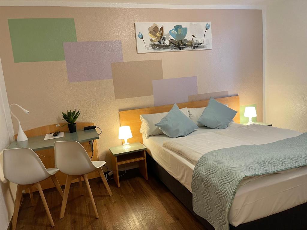 ein Hotelzimmer mit 2 Betten und einem Schreibtisch mit 2 Stühlen in der Unterkunft Residenz Hotel Wuppertal in Wuppertal