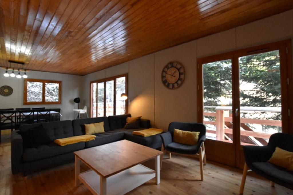 salon z kanapą i stołem w obiekcie Chalet de montagne w mieście Formiguères