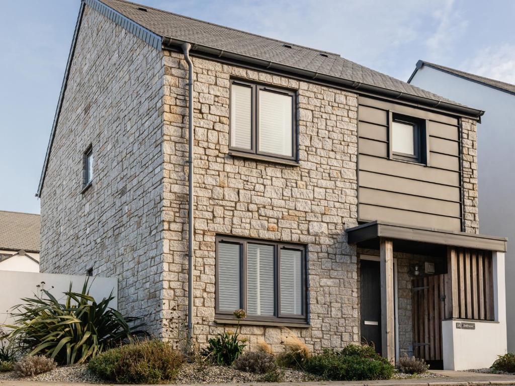 a brick house with black windows at Driftwood in Newquay