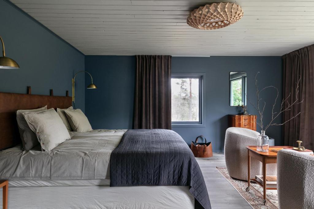 een slaapkamer met blauwe muren en een bed en een stoel bij Luxury family home near the water for eight people in Stockholm