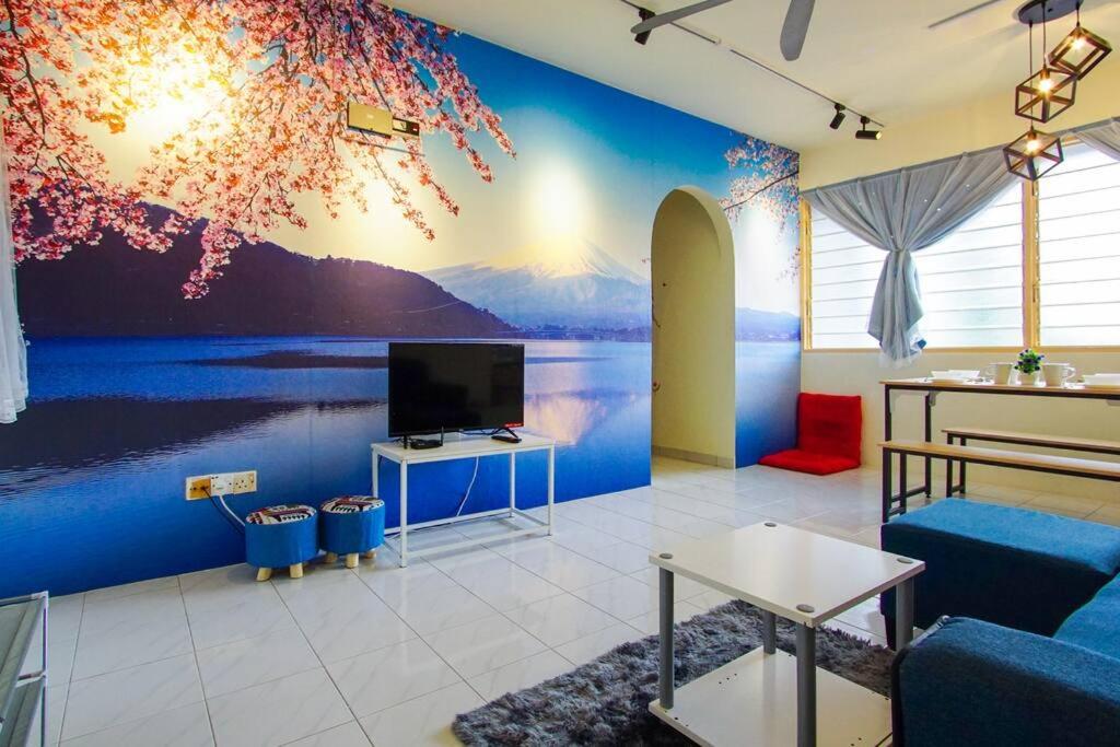 a living room with a mural of a lake and a tv at Fuji Home in Bayan Lepas