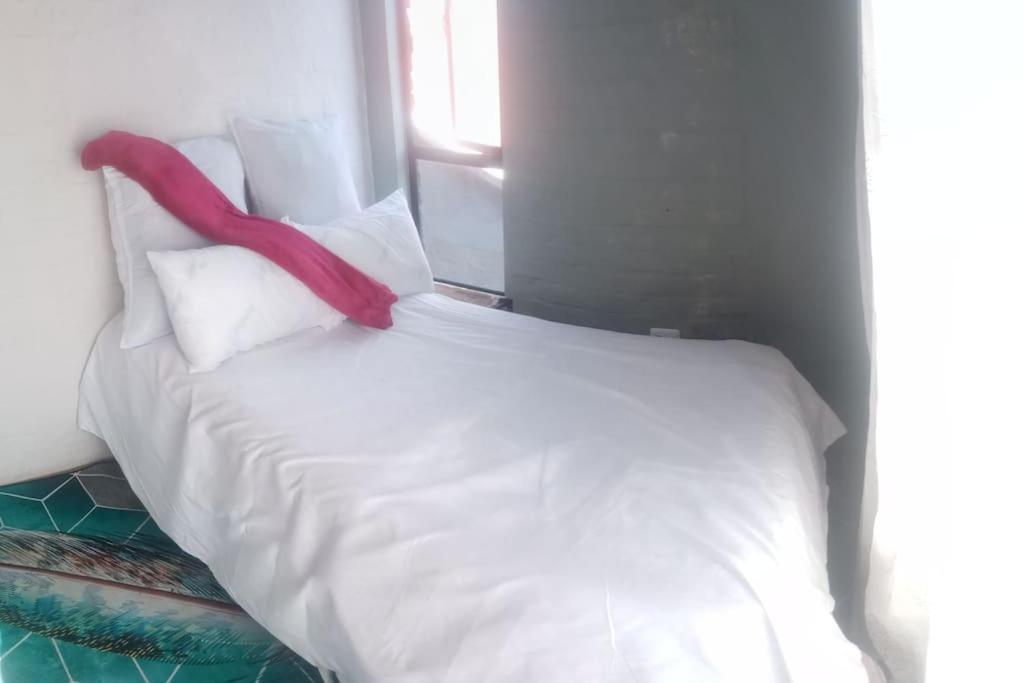 a white bed with a red ribbon on top of it at Located in the heart of the city in Johannesburg