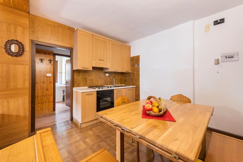 a kitchen with a wooden table with a bowl of fruit on it at Delizioso appartamento trilocale a Moena in Moena