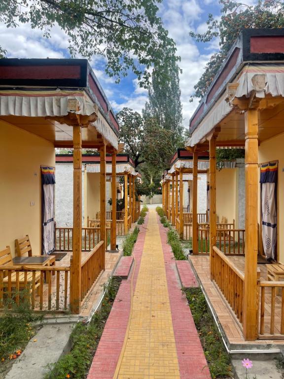 a row of wooden pavilions with a walkway at Chamba resort in Leh