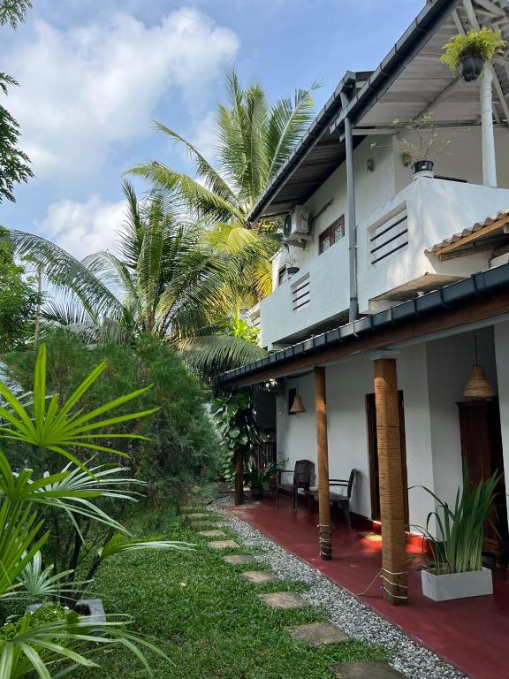 a house with a red walkway in front of it at Jungle Villa in Ahangama