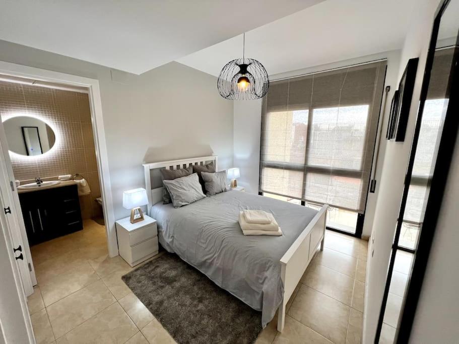 Un dormitorio con una cama grande y un baño. en Acogedor apartamento entero, en Terrassa