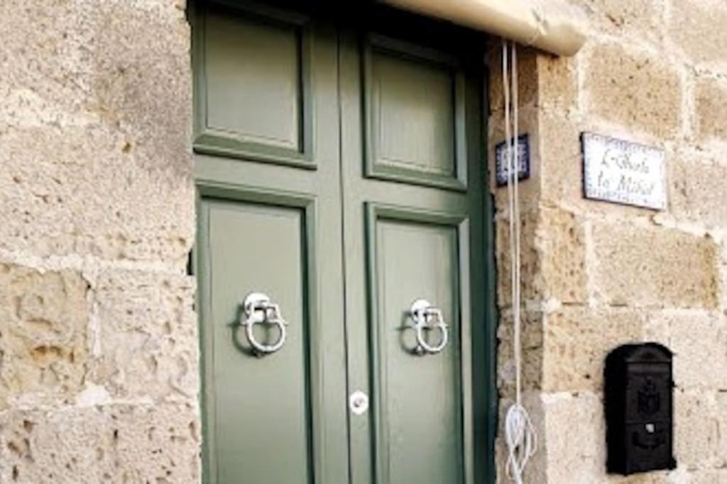 a green door in a stone building with at Charming 200 year old cottage with yard in Żabbar