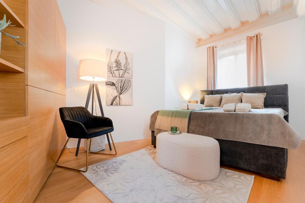 1 dormitorio pequeño con 1 cama y 1 silla en Historic Lodge in der Innenstadt Krems, en Krems an der Donau