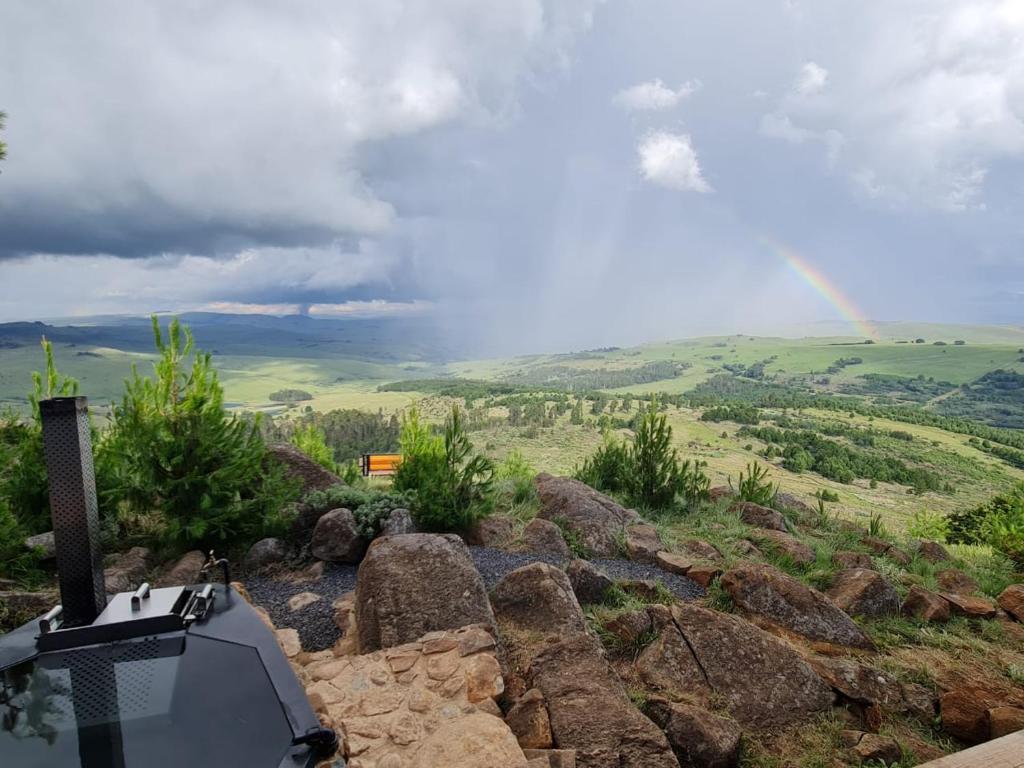 a rainbow over a hill with a tv and some rocks at Eagle View on Beumont in Dullstroom