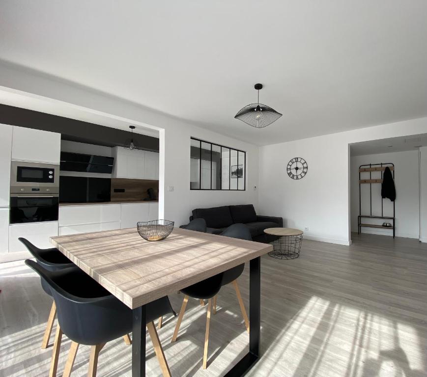 cocina y sala de estar con mesa de madera y sillas en Magnifique appartement à deux pas du centre ville!, en Quimper