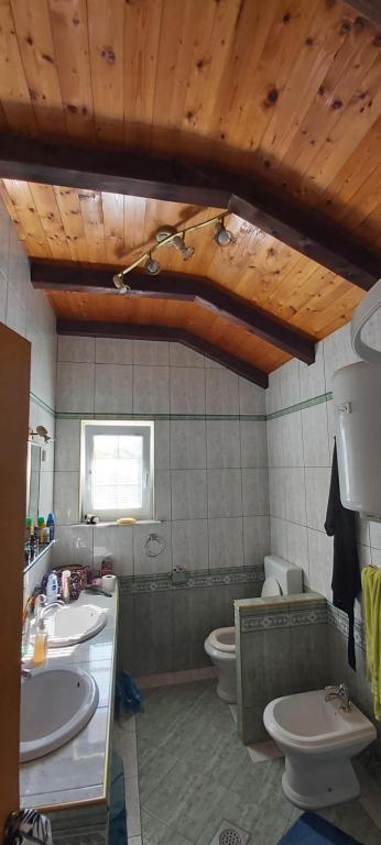 een badkamer met 2 wastafels en een toilet bij Vila Judita Žman in Žman