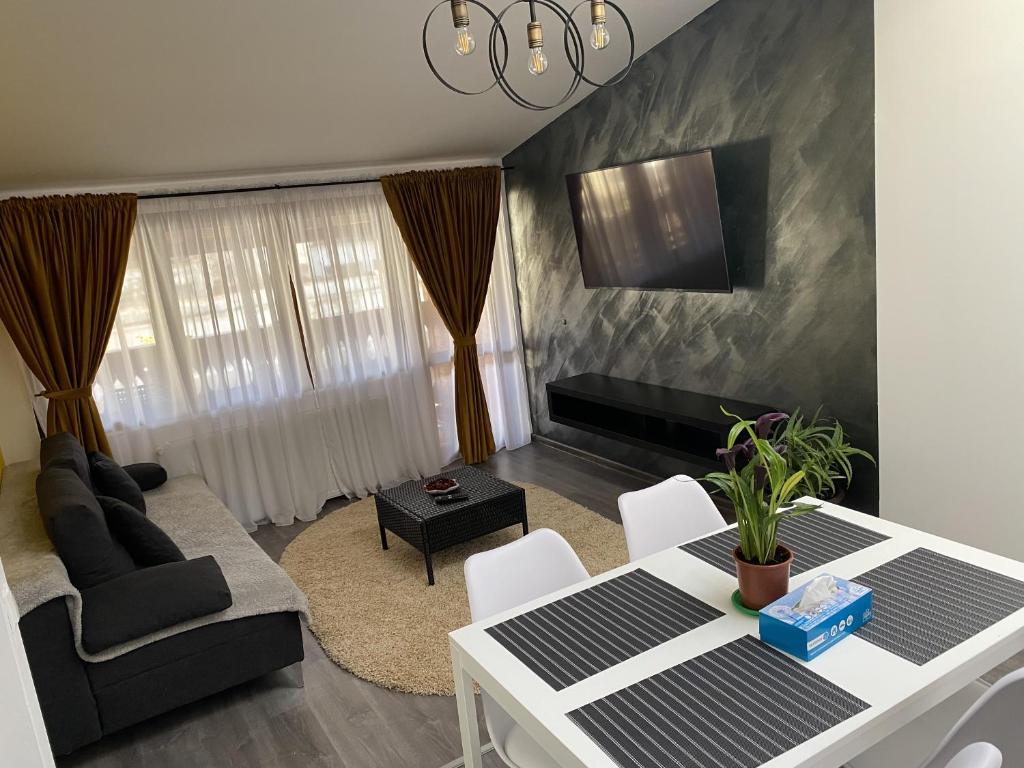 un soggiorno con tavolo e divano di Alvi Apartment Poiana Brasov a Poiana Brasov