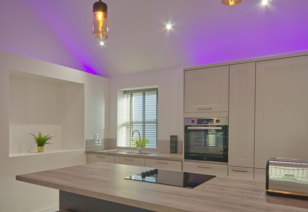 una cucina con luci viola sul soffitto di Harbour Heights, Luxury Coastal Apartment in The English Riviera, close to the Shops, Bars, Restaurants, Marina and Beaches a Torquay