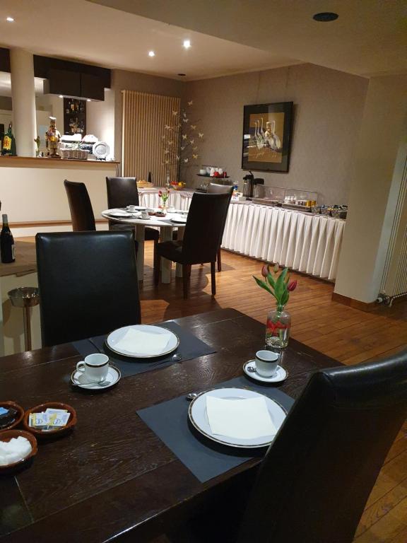 una sala da pranzo con tavolo, sedie e piatti di Carré a Lommel