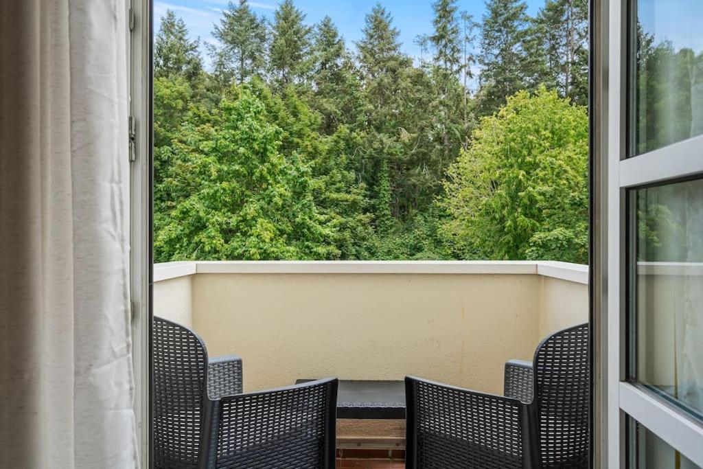 d'un balcon avec des chaises et une vue sur les arbres. dans l'établissement Grünes Wohnen in Düren, à Düren