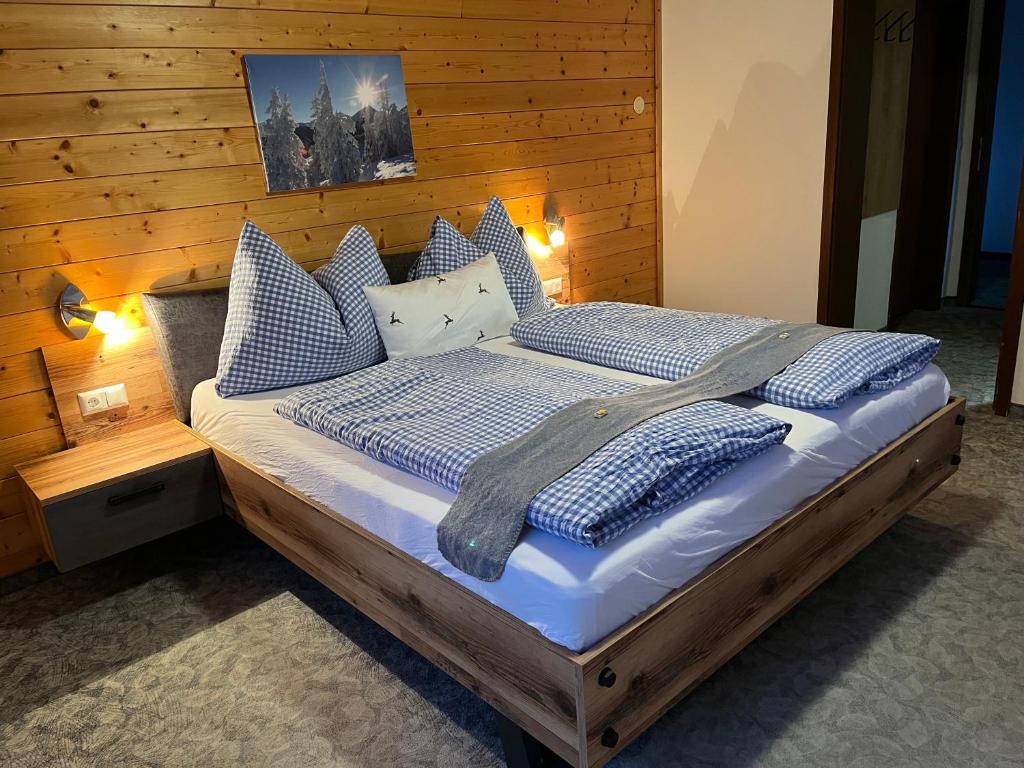 a bedroom with a bed with blue and white pillows at Pension Mitterwallner in Schladming