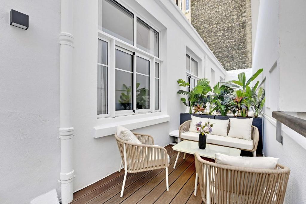 - une terrasse couverte avec des chaises, une table et un canapé dans l'établissement Modern Apartment - 2BR-6P - Eiffel Tower, à Paris