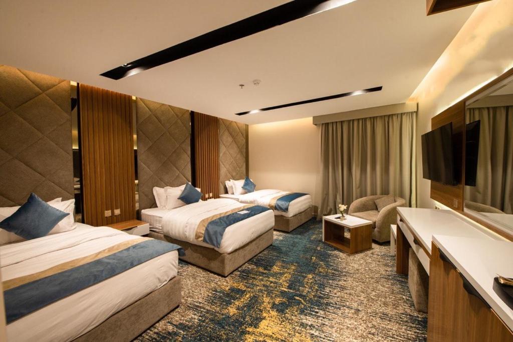 Habitación de hotel con 2 camas y TV de pantalla plana. en Grand day en Al Hofuf