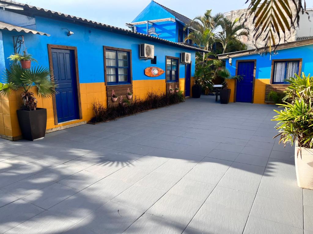 un edificio azul y amarillo con patio en Pousada La Croix, en Florianópolis