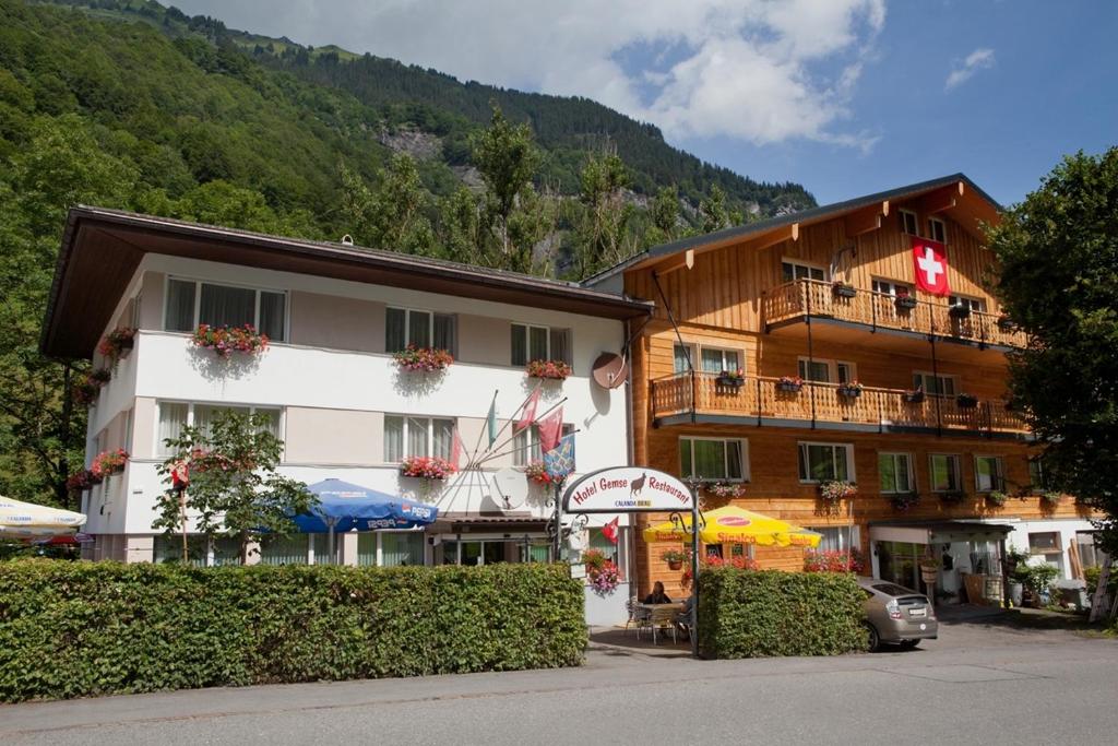 ein großes Gebäude mit einem Hotel in den Bergen in der Unterkunft Hotel Gemse in Weisstannen