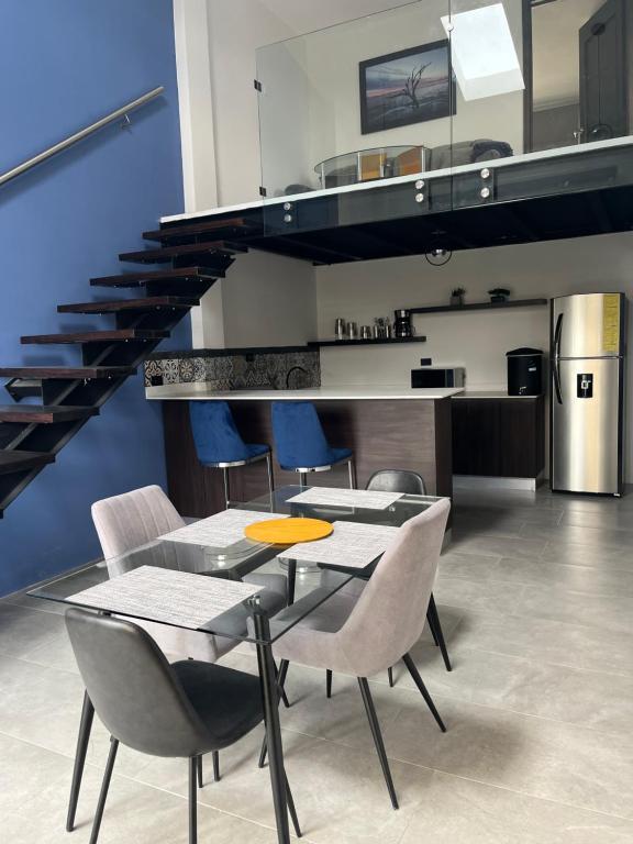 comedor con mesa, sillas y escaleras en Apartamento en Condominio Privado, en Quetzaltenango