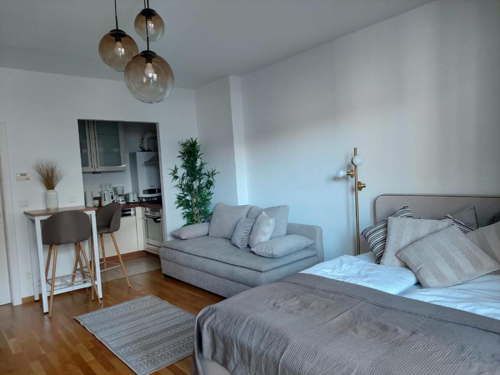 a living room with a bed and a couch at Balcony Apartment, 5 min Walk to First District in Vienna