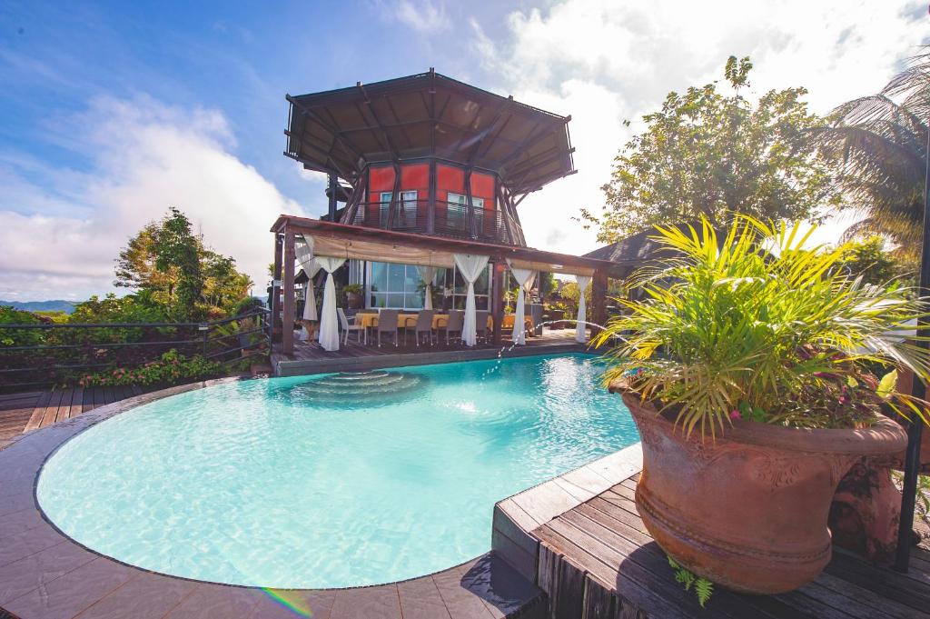 une maison avec une piscine et une tour dans l'établissement Sinurambi Bed & Breakfast - Mills Residence, à Penampang