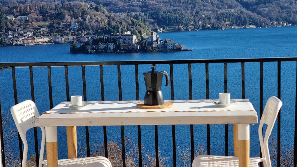 a table with a coffee pot and two chairs on a balcony at Luckylake in Pella