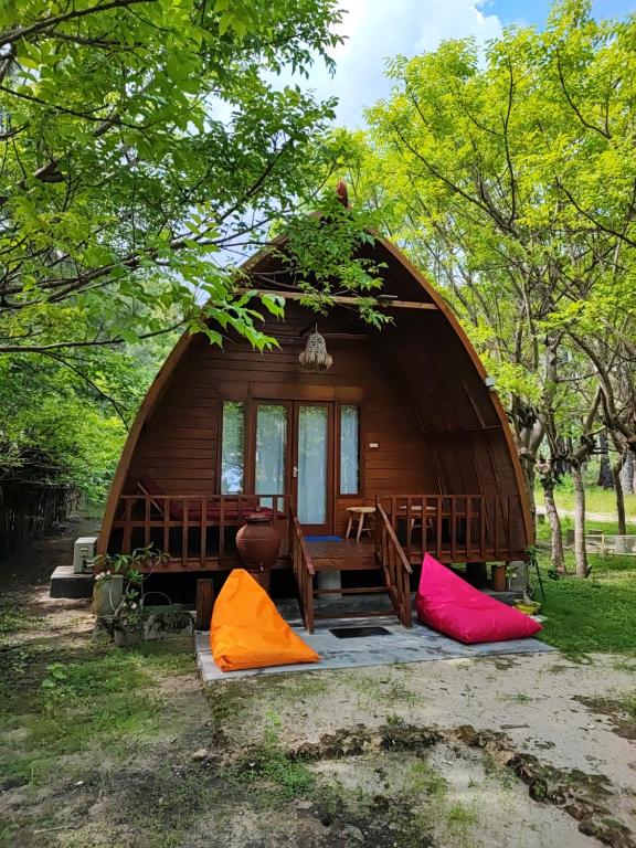 eine große Holzhütte mit einem Tisch und farbenfrohen Zelten in der Unterkunft Wajonata Sumba in Baing