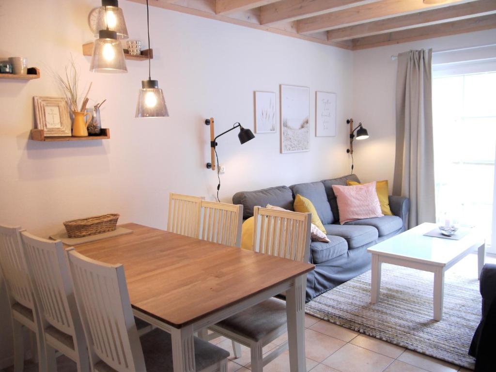 uma sala de estar com uma mesa e um sofá em Ferienhaus Oceansounds em Sierksdorf
