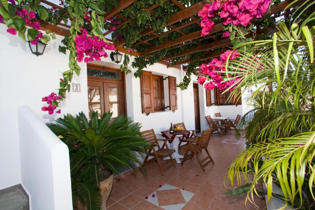 a courtyard with tables and chairs and pink flowers at Anastasia Studios Lindos in Líndos