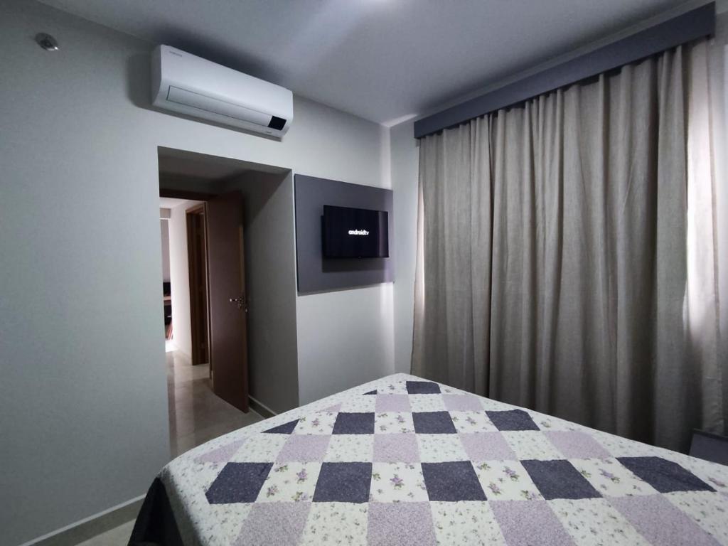 1 dormitorio con 1 cama con manta a cuadros en RECANTO DO BOSQUE _R3CALDAS, en Caldas Novas