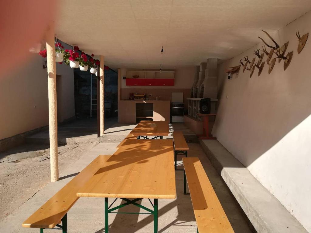 a row of wooden tables in a room at Casa Adelin in Eşelniţa