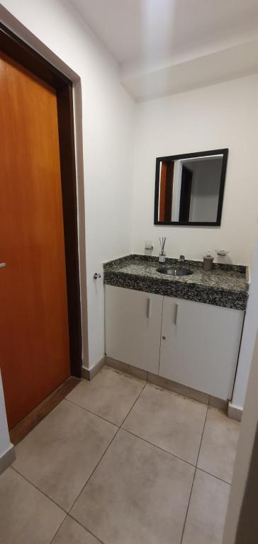 baño con lavabo y espejo en la pared en Alem 5 - Bon Repos en San Miguel de Tucumán
