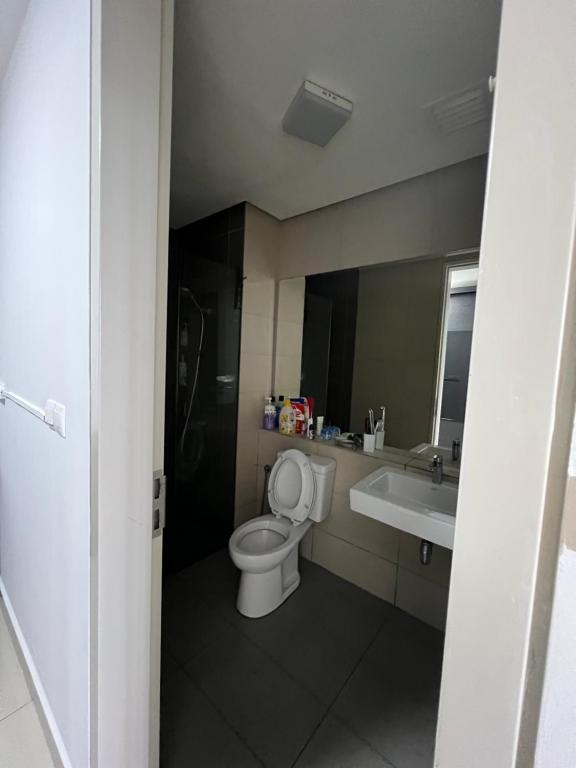 a bathroom with a toilet and a sink and a mirror at Paloma in Subang Jaya