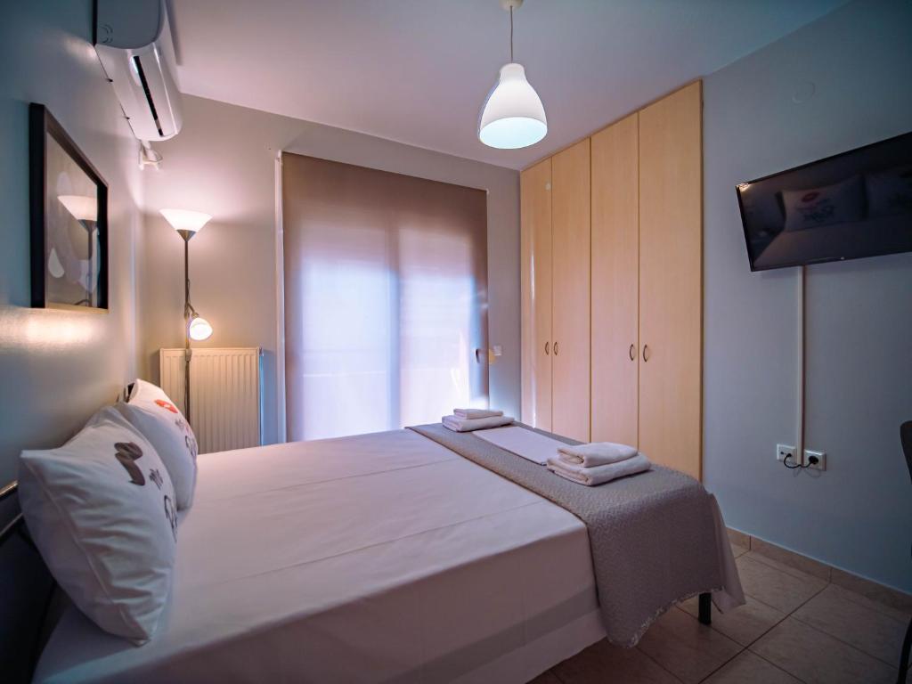 a bedroom with a large bed with two towels on it at Small Nest - Central Spot Apartments in Volos