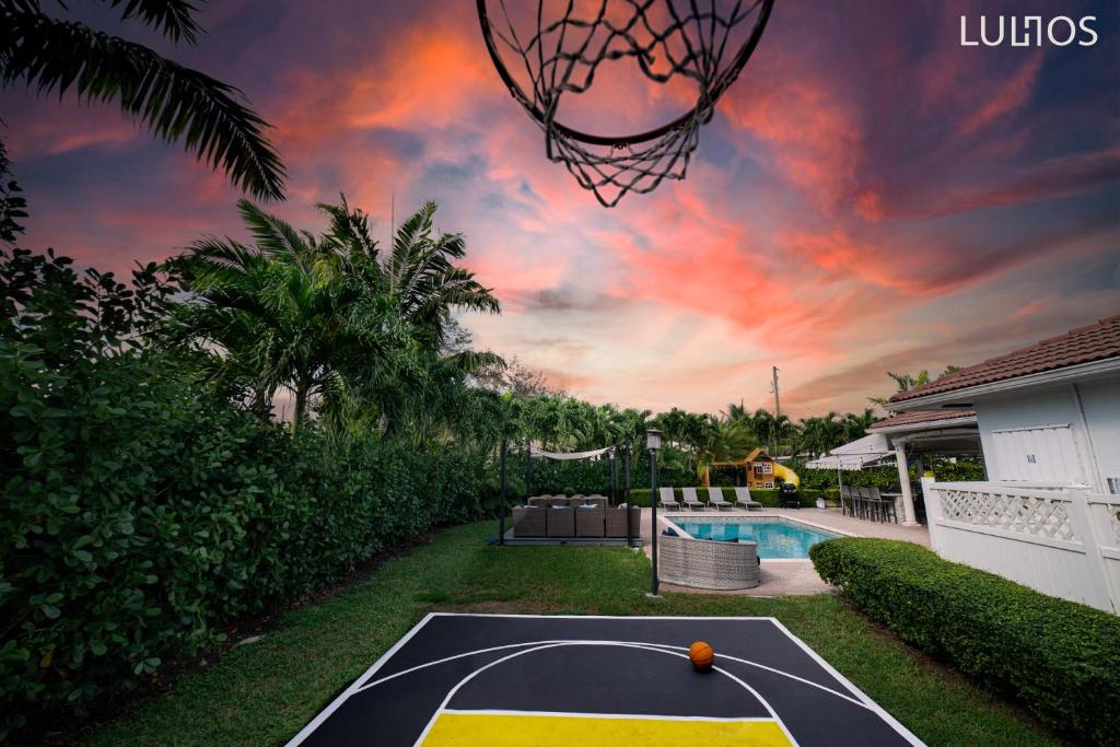 un aro de baloncesto en el patio trasero de una casa en Beautiful house heated pool, basketball L01 en Cutler Bay