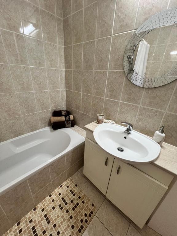 a bathroom with a sink and a tub and a mirror at Royal Seacrest new apartment B G2 ground floor in Paphos