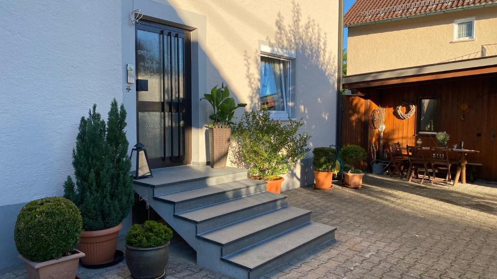 a set of stairs next to a building with potted plants at Ferienwohnung Schmid in Lautrach