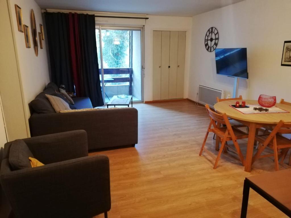 - un salon avec un canapé et une table dans l'établissement Appartement T2 Ax-les-thermes, à Ax-les-Thermes