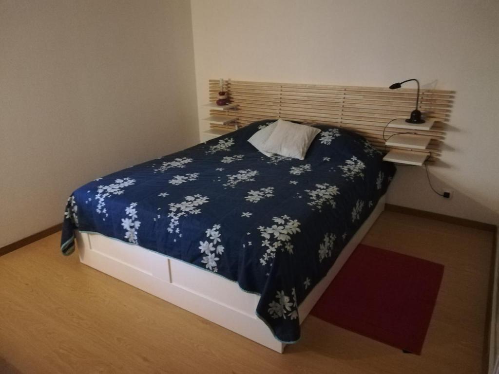 sypialnia z łóżkiem z niebieskim kocem i białymi kwiatami w obiekcie Appartement T2 Ax-les-thermes w mieście Ax-les-Thermes