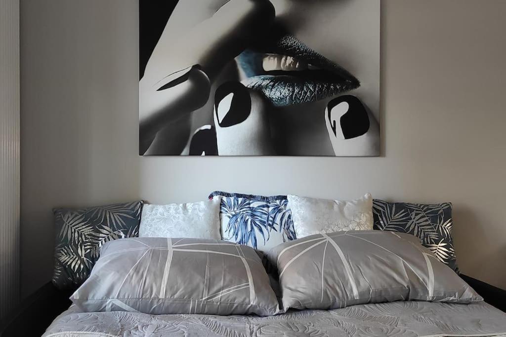 Una cama con dos almohadas y una foto de una mujer en Nowoczesny apartament w pobliżu centrum en Cracovia
