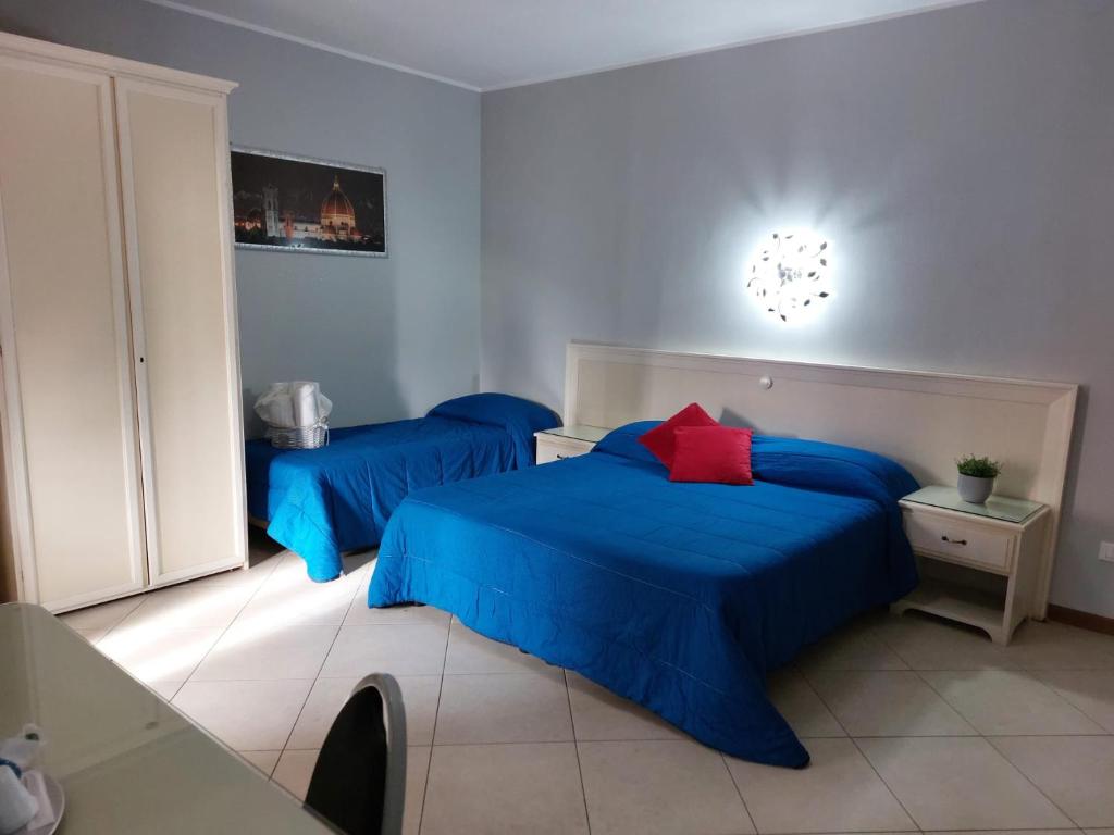 フィウミチーノにあるFiumicino Inn Airportのベッドルーム1室(青いシーツが備わるベッド2台付)