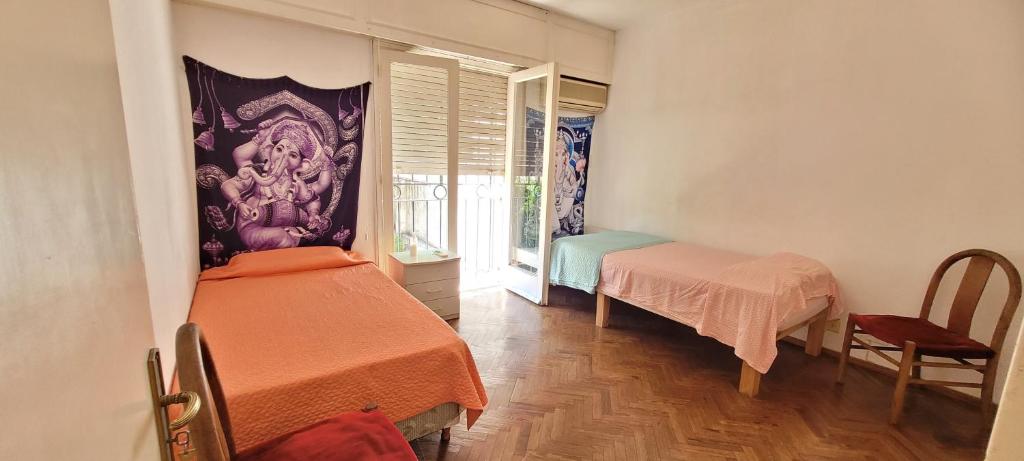 um pequeno quarto com 2 camas e uma janela em Habitaciones en el centro de Rosario em Rosário