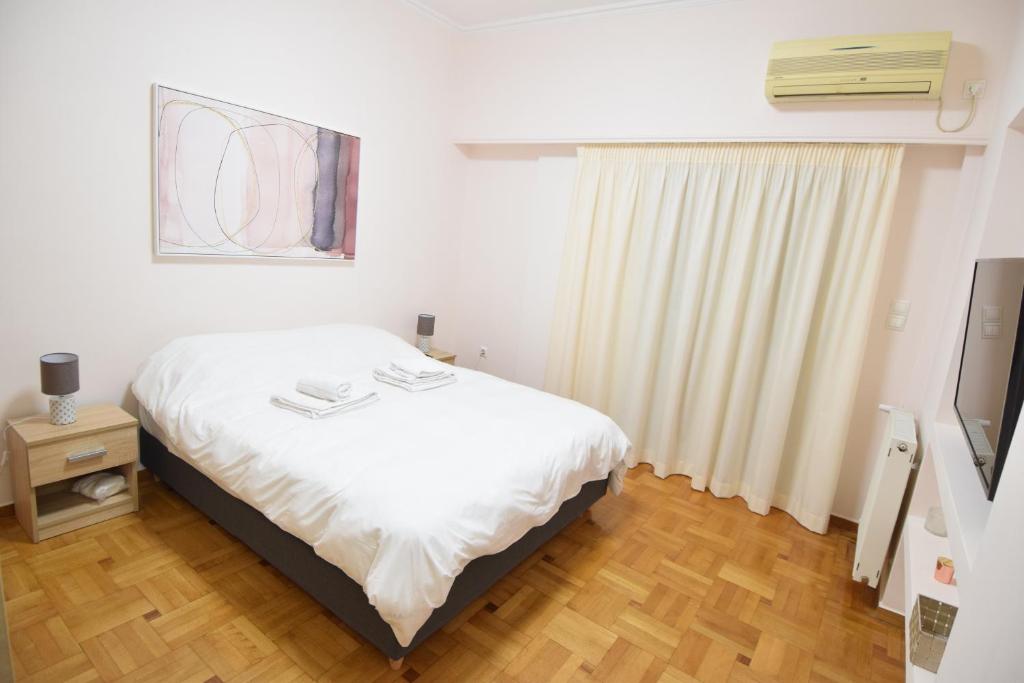 Posteľ alebo postele v izbe v ubytovaní acropolis super cosy apartment
