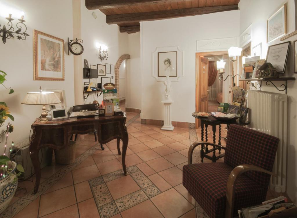 ein Wohnzimmer mit einem Schreibtisch und einem Stuhl in der Unterkunft Mondo Antico B&B in Cesena