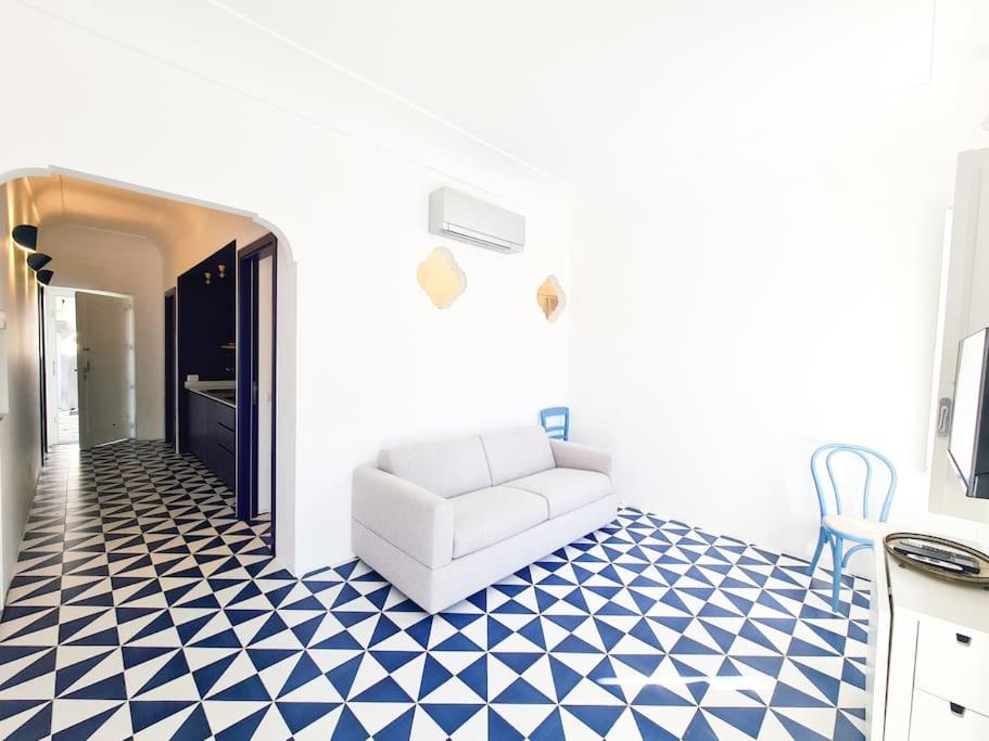 uma sala de estar com um sofá branco e um piso azul e branco em Il sorriso di Bri em Capri
