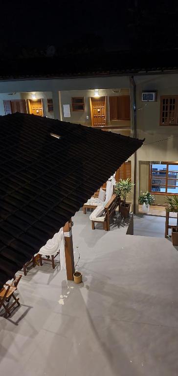 イーリャ・グランデにあるPousada Sakura Rio Marの椅子と大きな屋根が備わる広い客室です。
