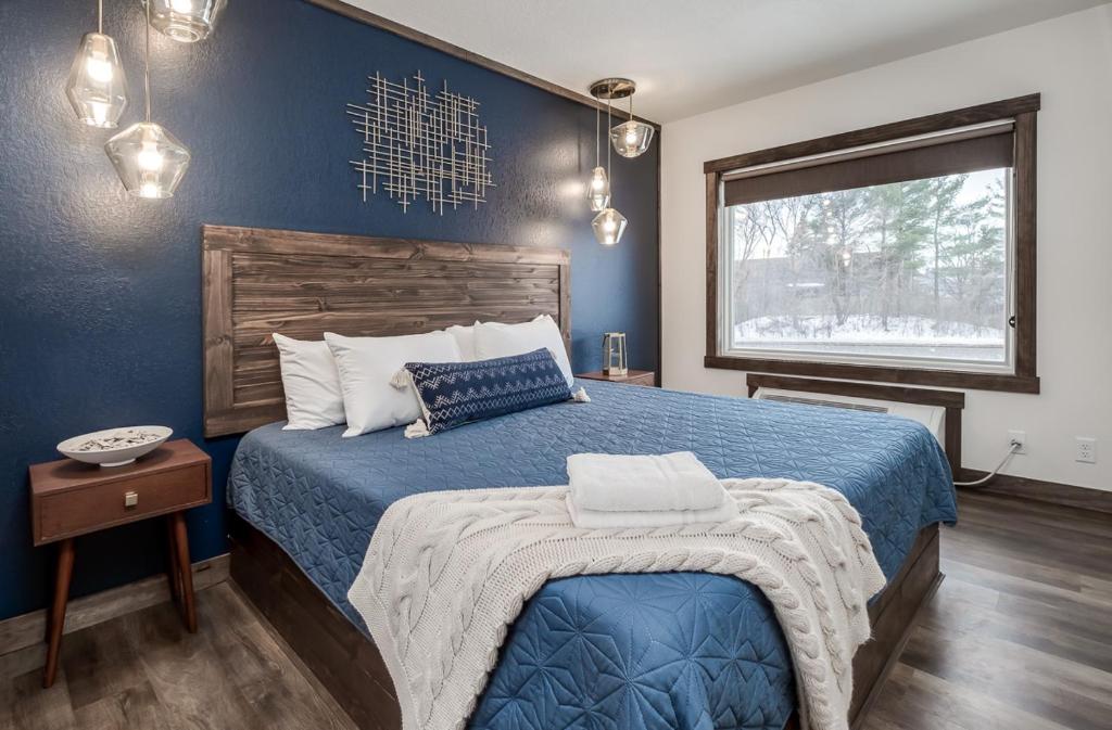 Dormitorio azul con cama y ventana en The Harbor Hotel Chic, Retro Hotel, en Prescott