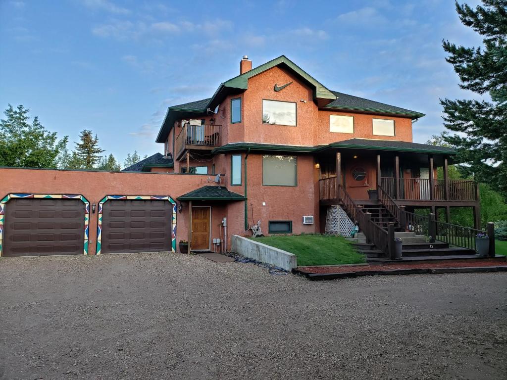 a large brick house with two sets of garage doors at South Africa House Guest Lodge in Wainwright